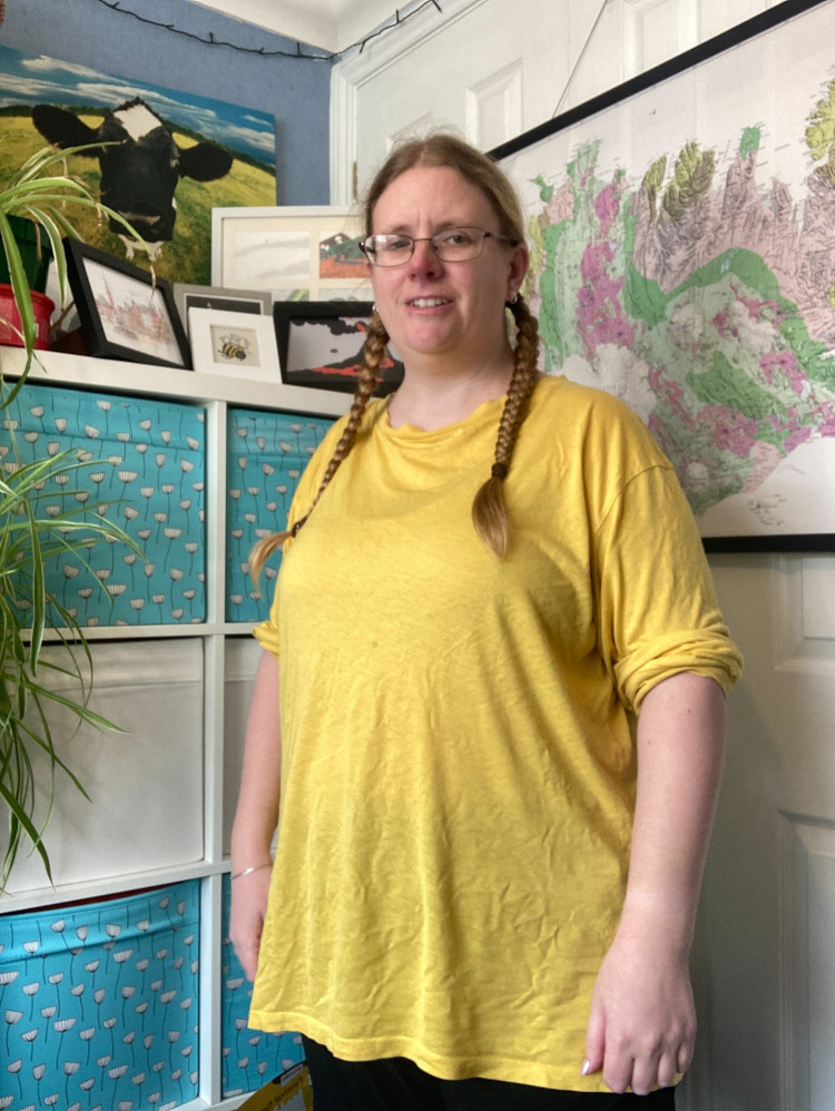 Me in my office in a very floaty semi-see-through yellow long-sleeved top although I've rolled the sleeves up to above my elbows because they're longer than my arms.