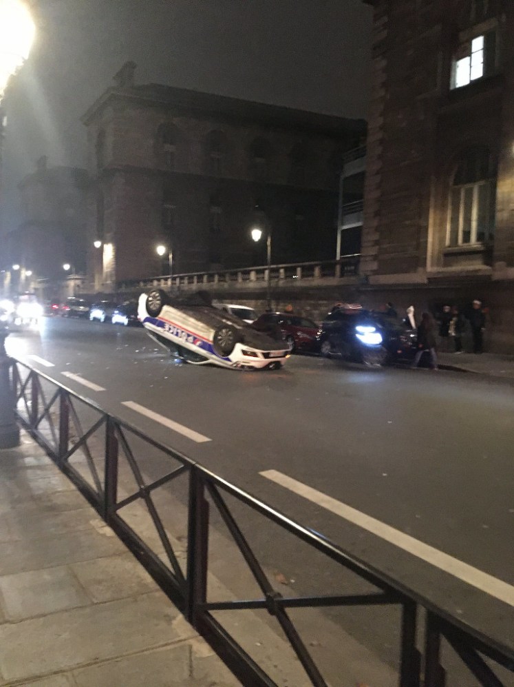Police car on its roof outside Paris's central police prefecture