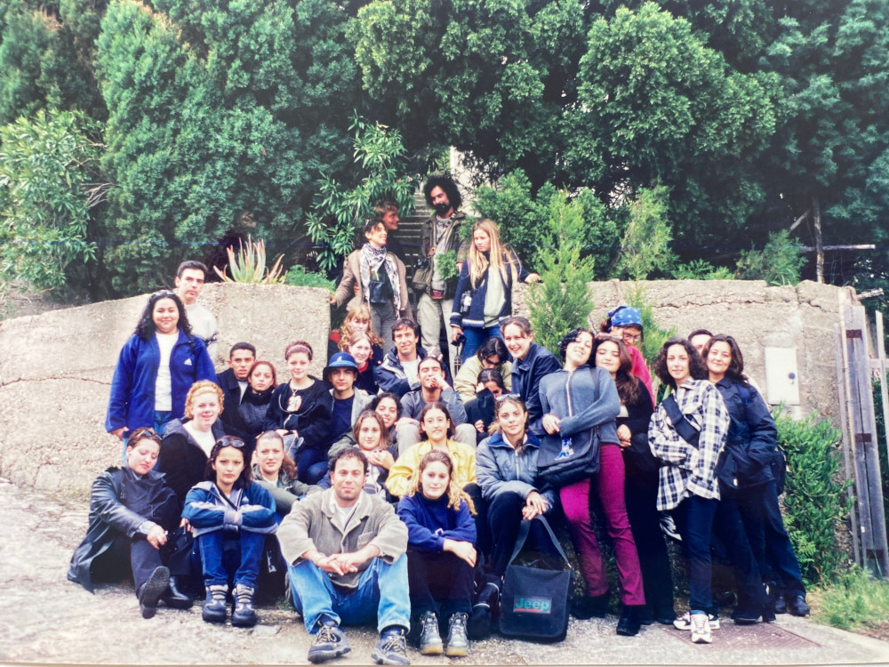 Another group photo, this time in better weather, gathered around a gap in a wall at the bottom of some stone stairs.