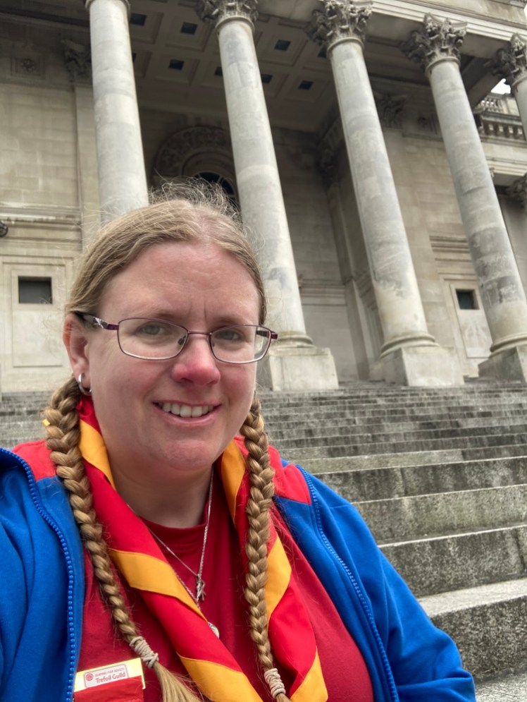 Me in Trefoil mode - blue "uniform" jacket, red t-shirt and red neckerchief with gold border, sitting outside Portsmouth Guildhall during the AGM in June.
