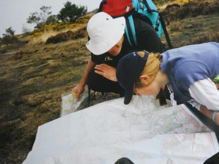 Mr Lowe and Catherine have the map unfolded and are crouched on the heath examining it. It's a big OS map and it's fully unfolded.