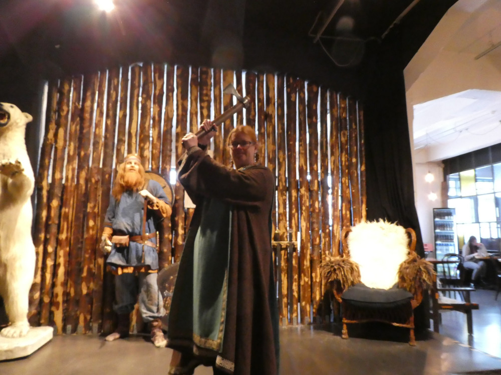 Me again, wearing a long brown dress with a green over-tunic, holding a long axe raised above my head. It's similarly blurry.