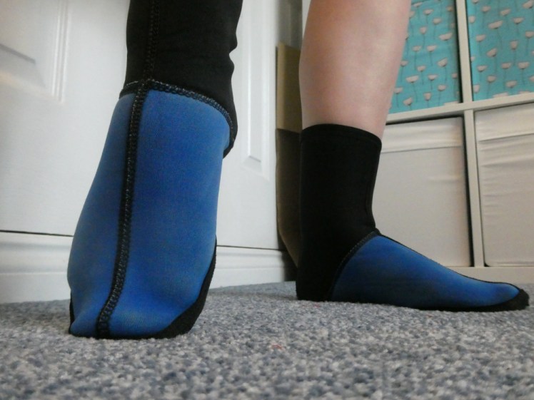 Close-up of my feet in neoprene socks. The uppers are bright blue, the soles and ankles are black.