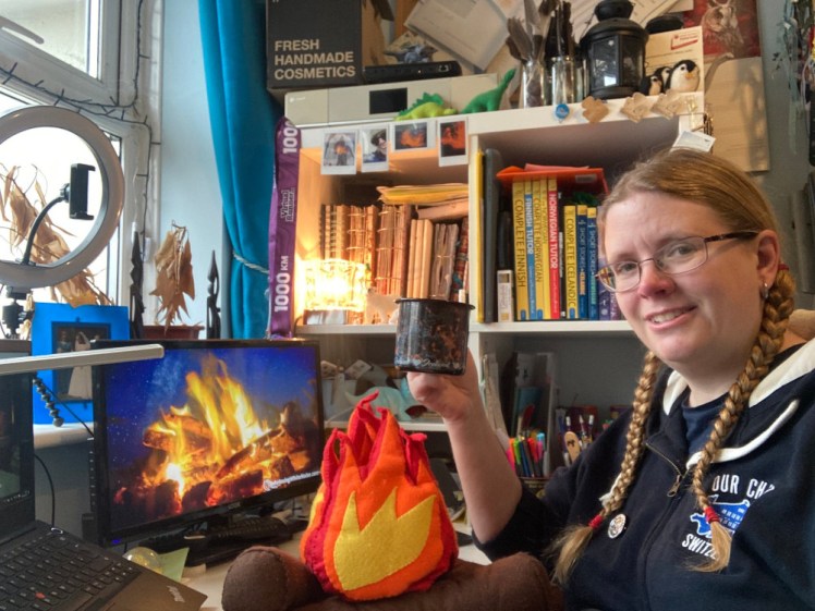 Me at my desk with a felt campfire in front of me and a campfire video playing on my second screen. It's broad daylight, not January evening but ignore that.