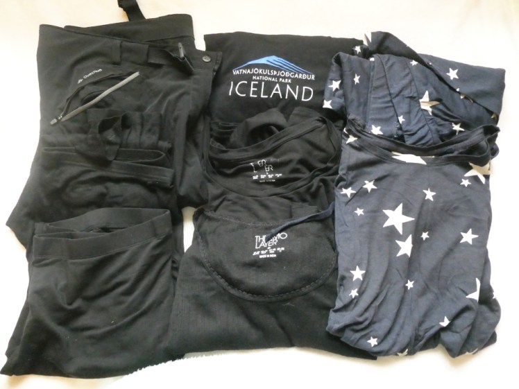 A nicely-folded (sort of!) pile of black trousers, black t-shirt, two sets of black thermals and a pair of navy starry pyjamas.