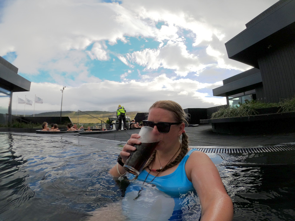 Me sitting in the deeper pool at the back, drinking from a pint/half litre glass of Pepsi. In the background, a woman in a hi-viz jacket is fetching cycle race winners from the hot tubs. Yep.