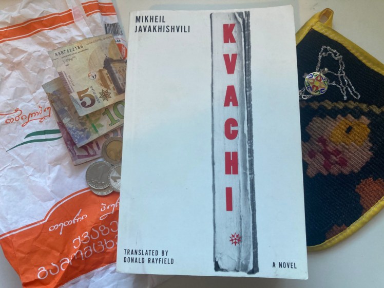 Kvachi lying on my desk surrounded by a Georgian bread bag and little pile of money, with my kisa glove and enamel jewellery on the other side.