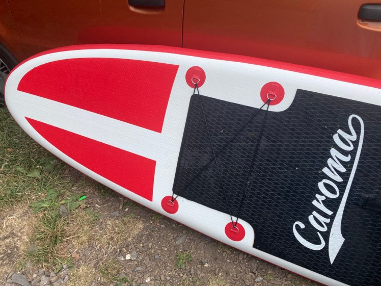 Close-up of the nose of the board. It's a white base with an asymmetrical split red cone at the end. Red circles mark the attachment points for elastic webbing and the deckpad is black.