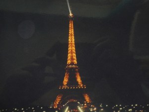 The Eiffel Tower lit up in yellow at night, as seen from a moving coach twenty years ago.