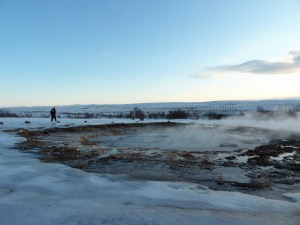 The Strokkur geyser's pool simmers away, surrounded by snow and ice, which is especially glassy and slippery from constantly being remelted by regular explosions of hot water.