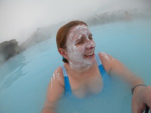 Me, laughing the Blue Lagoon, with a white mud mask on my face. The mist from the hot water hitting the cold air is blurring out the background a bit but you can see the bright baby blue of the water really well.