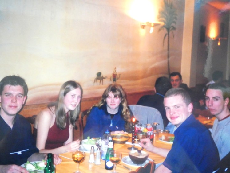 The gang in a restaurant somewhere in Paris. It's a photo of a film photo, so the picture is washed out, 90s-style.