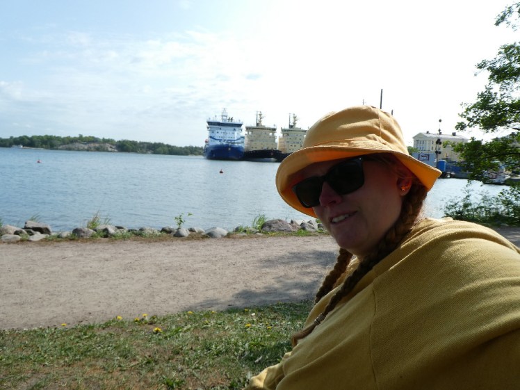A selfie in a yellow jumper and bucket hat, sitting opposite Finland's entire icebreaker fleet.