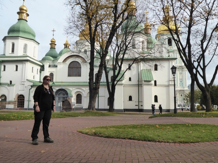 A timer selfie where I look extremely awkward, dressed all in black and not looking at the camera. Behind me is St Sophia's Cathedral in Kyiv.