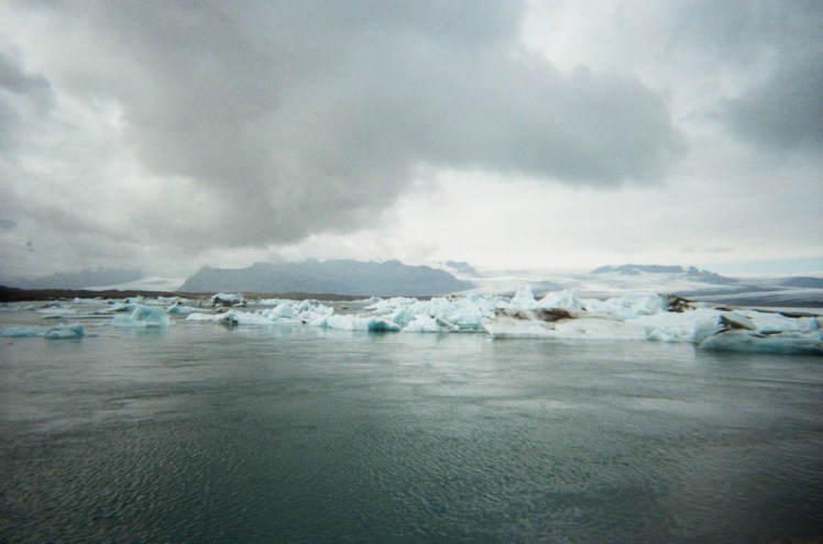 Icebergs floating in the glacier lagoon under a heavy sky.