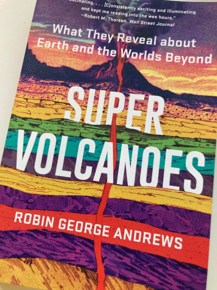 Close up of the Super Volcanoes cover, in stripes of purple, yellow, green and blue, with a red line of magma coming up to the surface.