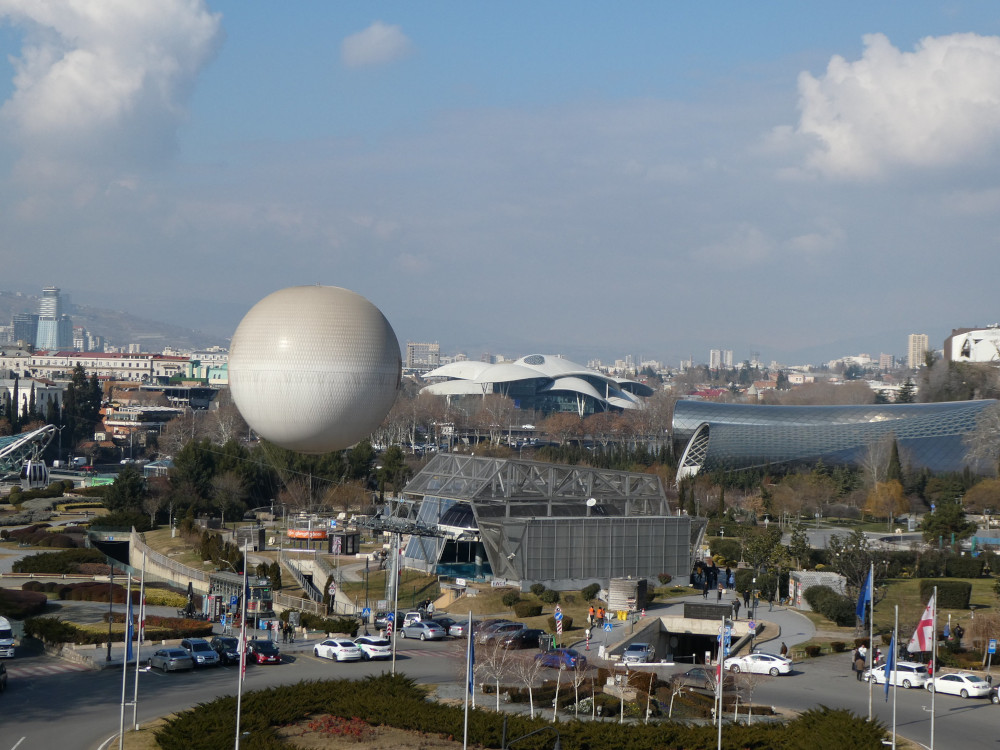 A closer view of what's going on beyond the balloon. You can see the tube-like structure of the music hall and the mushroom-like flakes of the Justice House.