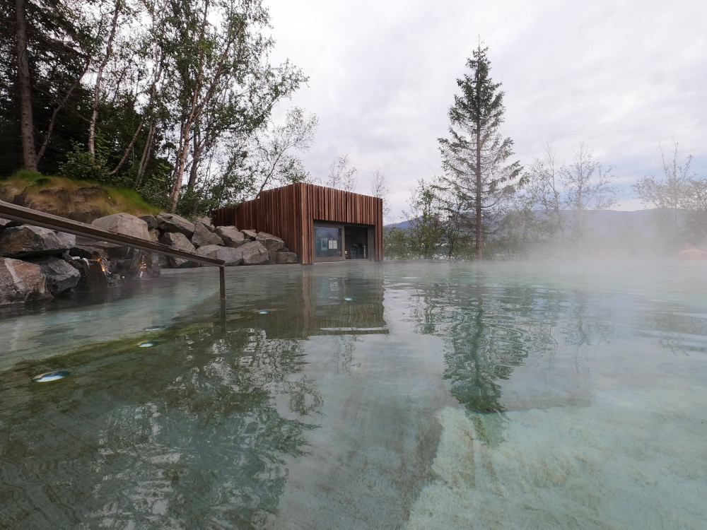 A view from the gentle slope across to one of the Forest Lagoon's swim-up bars. There is a layer of haze floating just above the hot water.