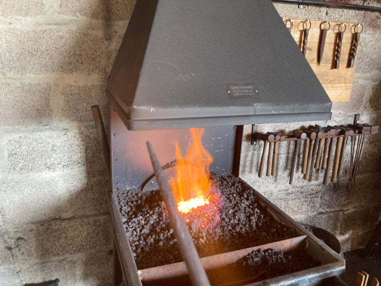 My poker, hammered into a point, held out above the forge which is now a roaring little fire.