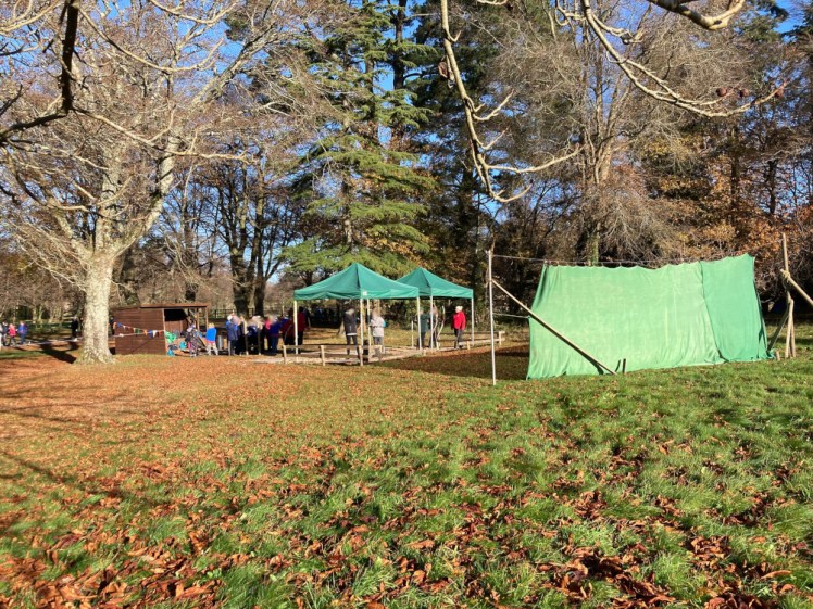 The archery range and the tiny figures of various Guides & Rangers either holding bows or waiting their turn. It's seen from outside the safety line so it's a bit of a distance away.