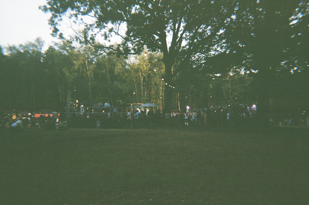 The Patrol Games arena. It's a film photo taken under trees in early evening so it's a bit noisy and grey-green but you can see the stands in the four corners and a lot of people gathered around.