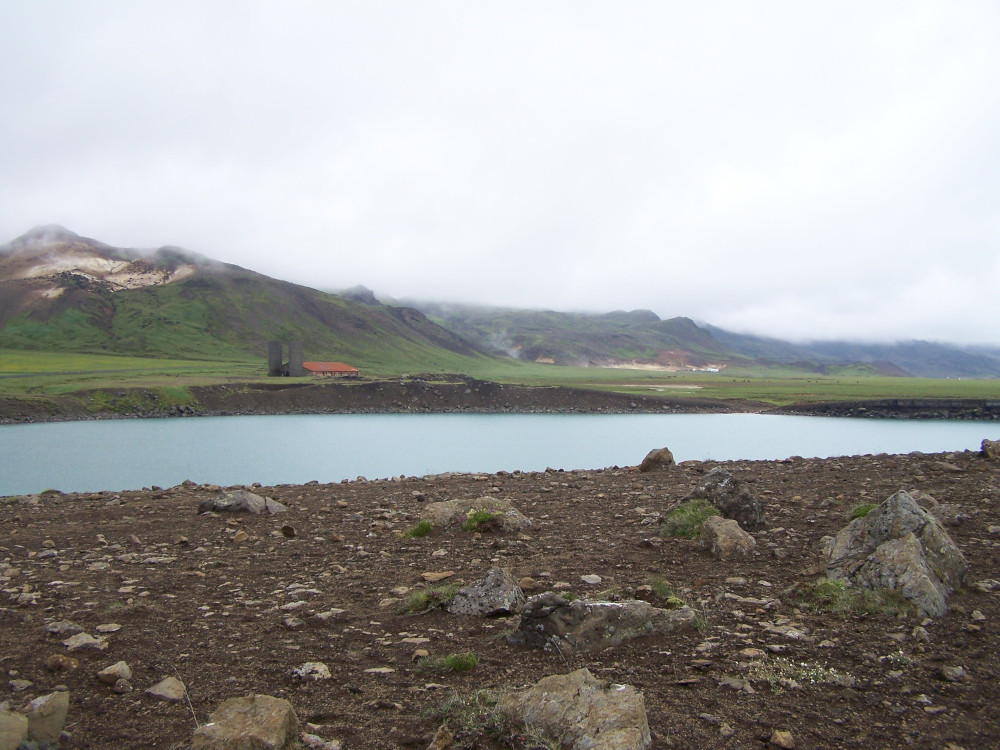 Graenesvatn, a deep green-blue lake with mountains rising up behind it, mostly hidden by low cliffs.