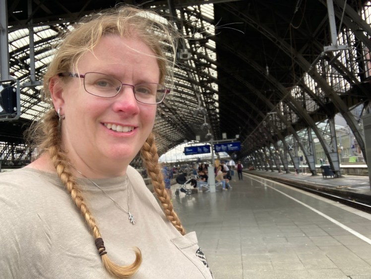 A selfie at Cologne station, with the wrought iron roof behind me because I'm standing just outside.