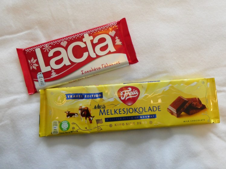 Greek Lacta chocolate, in a red and white package, vs Norwegian Freia chocolate, in yellow. Freia is longer and the package looks a little less elegant.