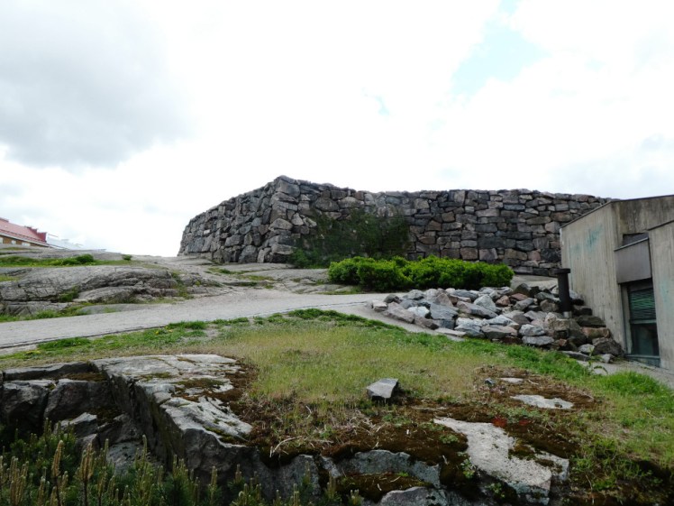 The hill with a low rock wall on it. From this angle, you can't see the green dome but you can see the side of a concrete building just about built into the hill.