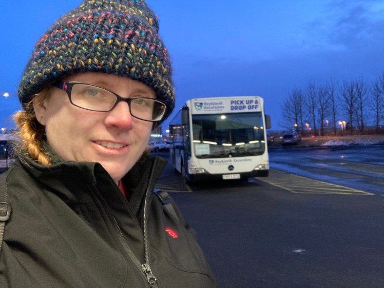 A selfie in the early evening with a Reykjavik Excursions pick-up bus. I'm wearing a navy knitted hat and my heated coat.