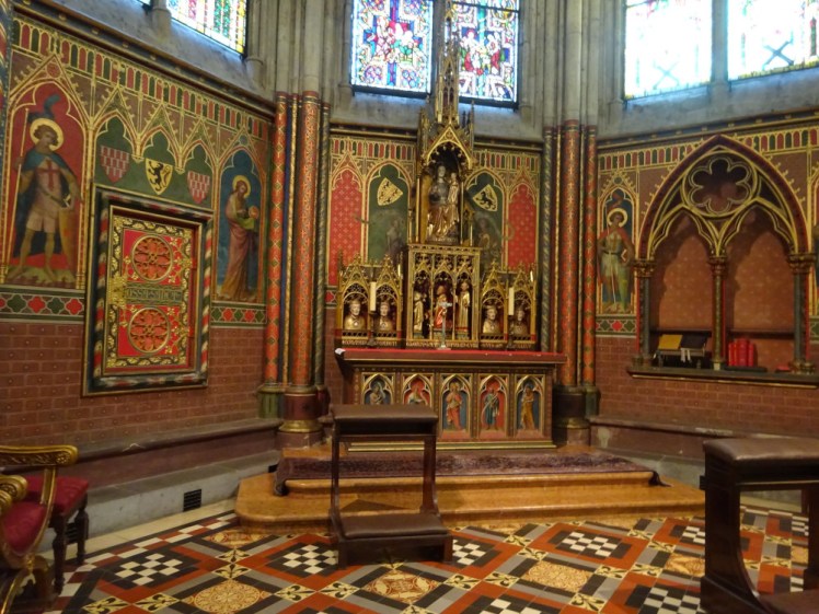 One of the chapels in the ambulatory. It's lined with red brick and has niches painted on the wall, containing saints. There's a lot of gold, especially in the altarpiece. The delicate columns are painted in red, gold and green patterns. The effect is like a red version of the blue splendour of the lower chapel at Sainte-Chapelle in Paris.