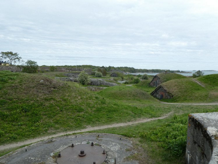 A field of military buildings hidden under dome-shaped turf roofs. It looks like Hobbiton or the Teletubbies' home.