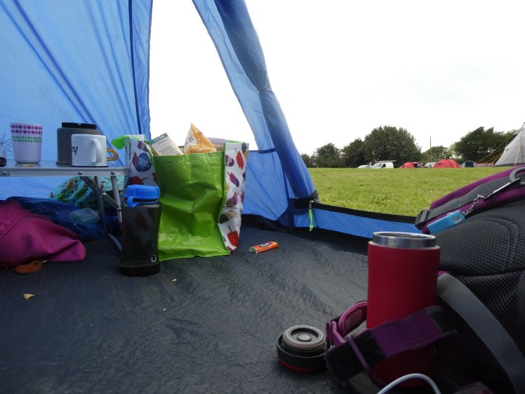 An untidy tent with stuff not stored nicely in their bags