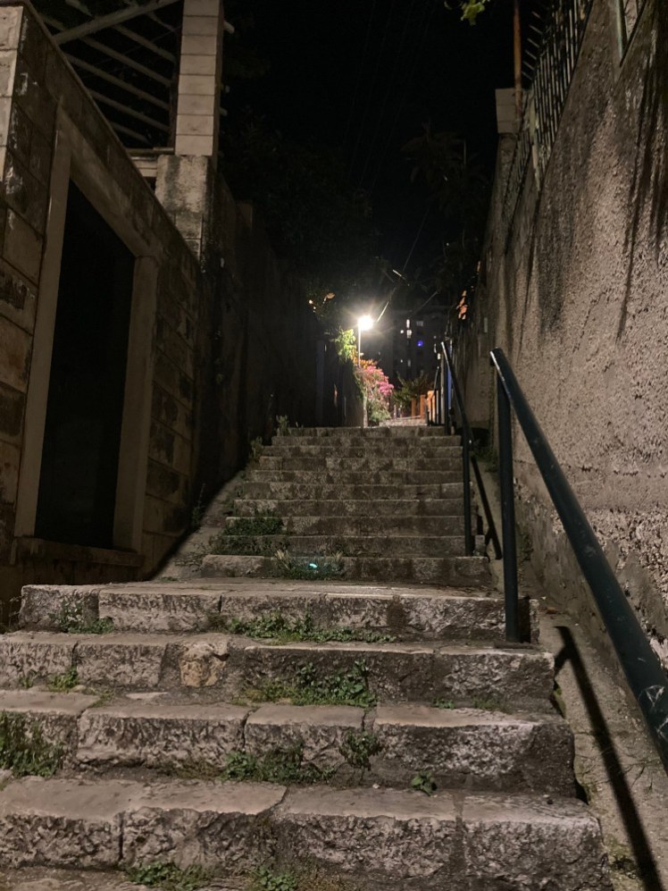 Looking up steep stone steps in the dark, between the port at sea level and the apartment halfway up the town.