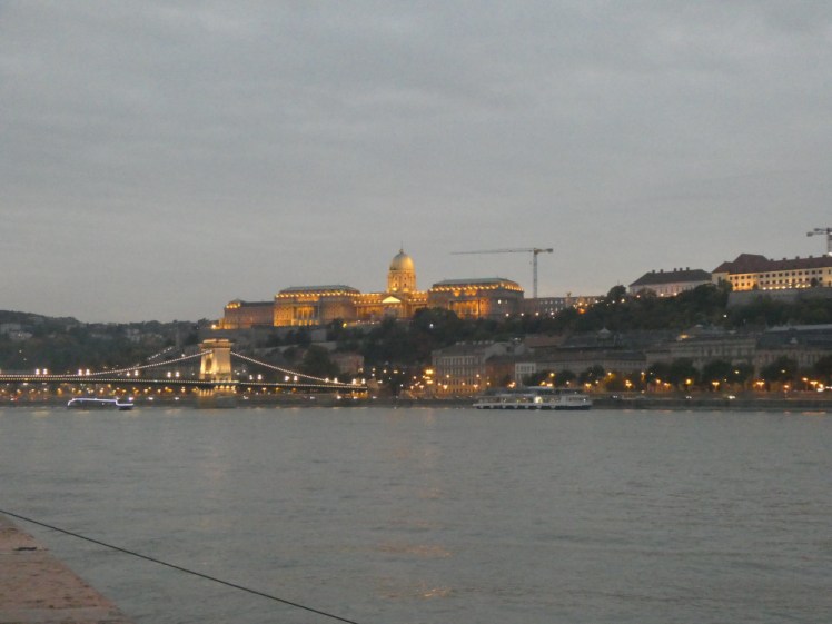 Buda Castle, on the other side of the river, lit up as the sun begins to go down.