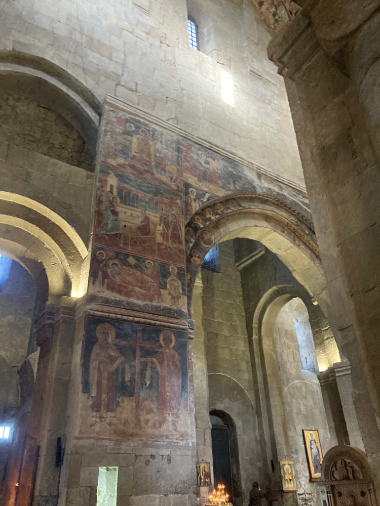 The remains of bright-coloured frescoes on the wall, now darkened with age. Once, these would have been on every surface but they were painted over or washed off for a visit from the Russian Tsar in the 19th century - which never even happened in the end.