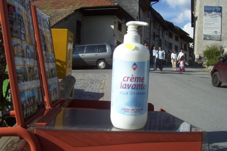 A bottle of Leader Price-branded liquid soap on a bench.
