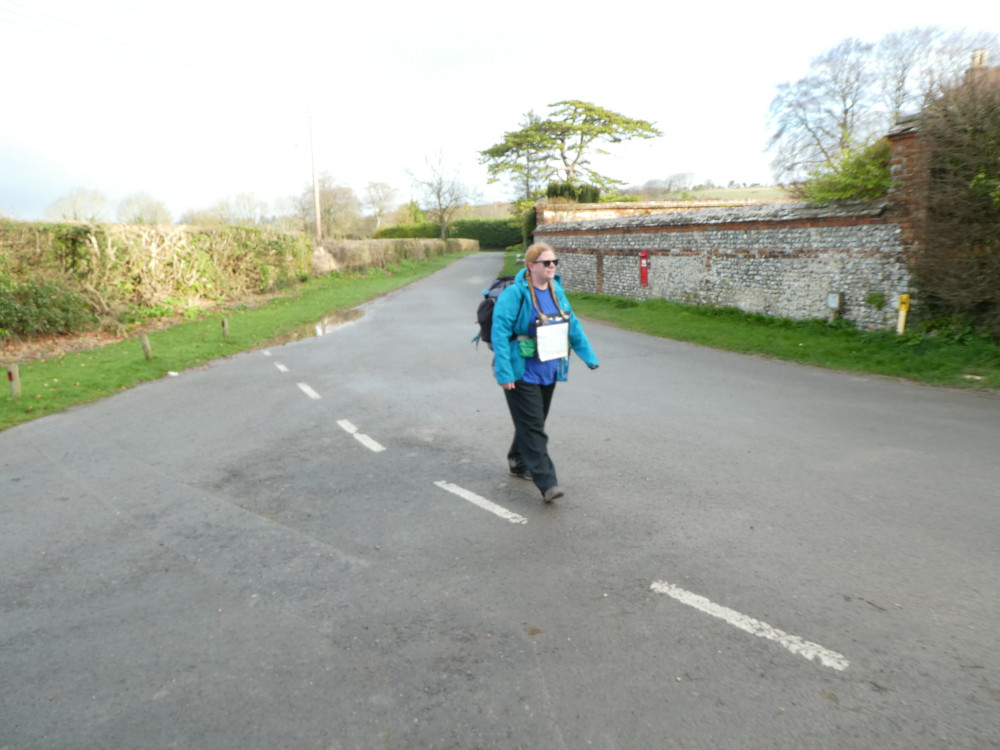 A timer selfie in Chilcomb, walking along the deserted village road in the bright light of the early morning with my map around my neck.