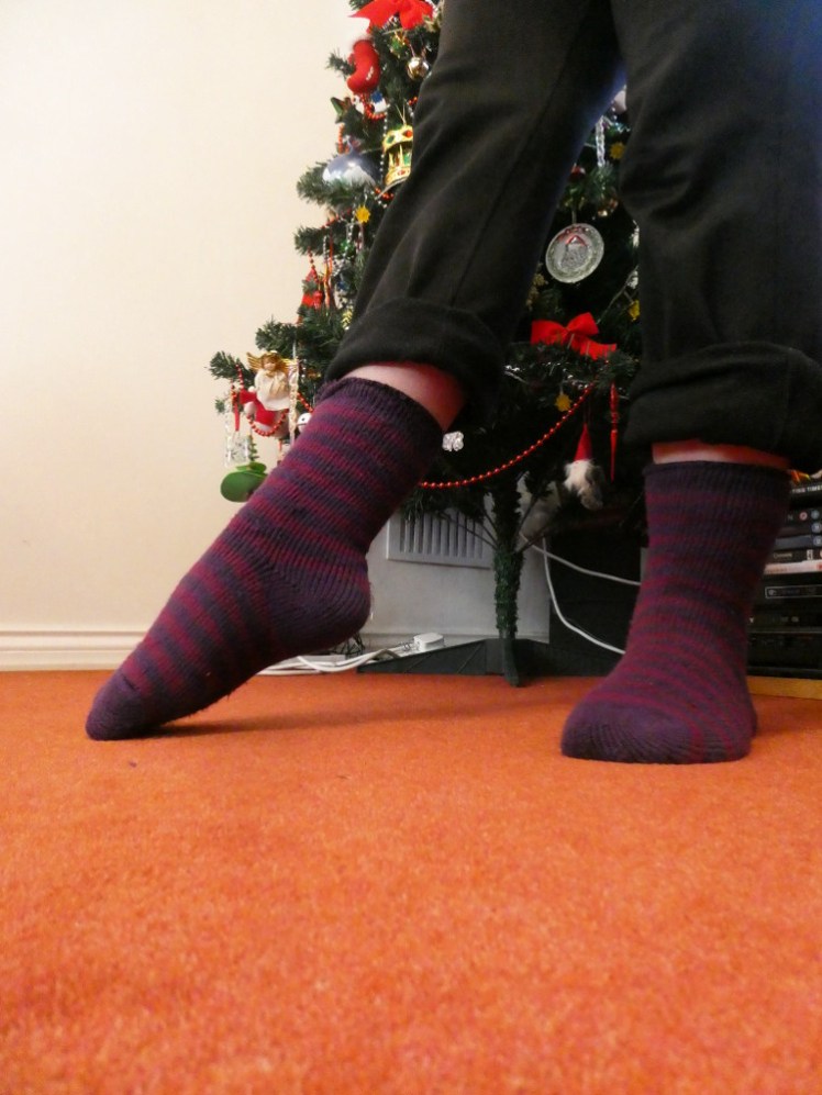 Me from the knee down, my trousers rolled up to show off my thick fluffy stripy purple socks.