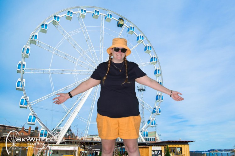 One of my greenscreen photos showing me in a navy t-shirt and yellow shorts & hat, standing outside the SkyWheel. Judging by our relative sizes, I must be King Kong. At least this view of the wheel isn't dominated by cranes.