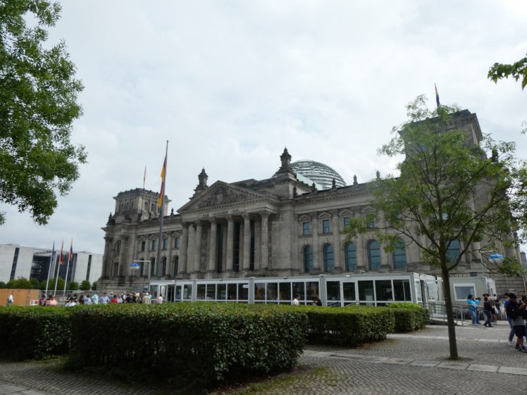 The Reichstag Building, a large stone classical building with a glass dome on top, barely visible behind the building's various decorative towers, pediments and other bits and pieces on the roof.