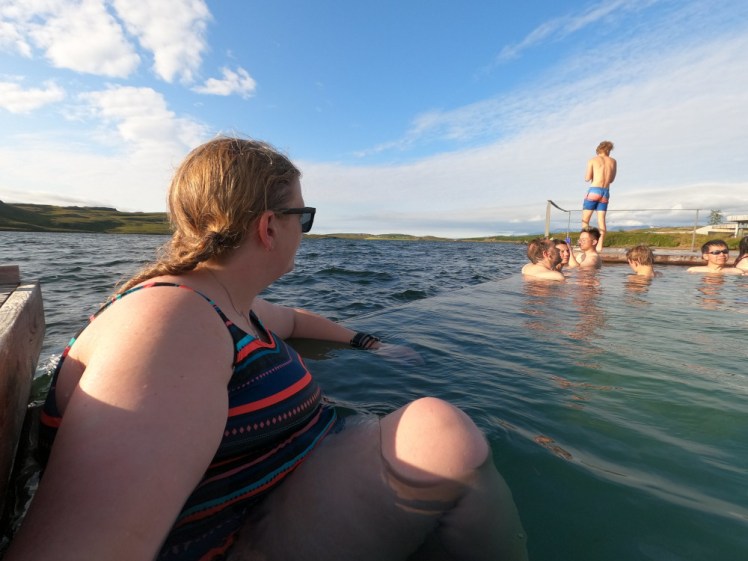 Vok Baths: Me sitting on the edge of one of the floating infinity pools, overlooking the lake.