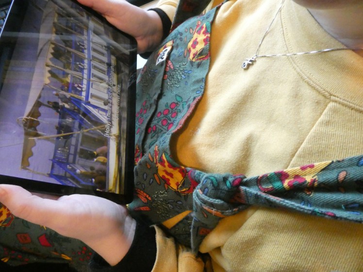 A close up of me sitting holding the tablet. I'm actually at my desk but if I wasn't wearing the same clothes as in all the pictures, you might think I'm on a plane. My elbows are tucked in, I'm holding the tablet horizontally in both hands and an episode of Tough Boats in Egypt is on the screen.