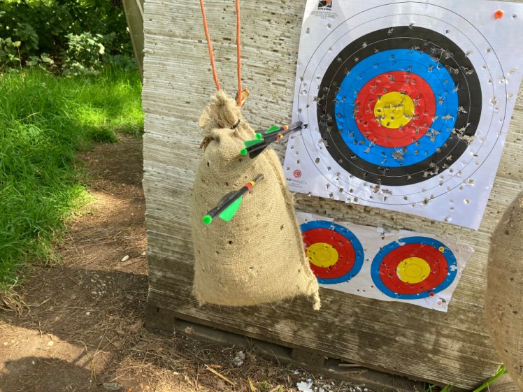 Three crossbow bolts nicely grouped, two in the target and one in the hanging sack