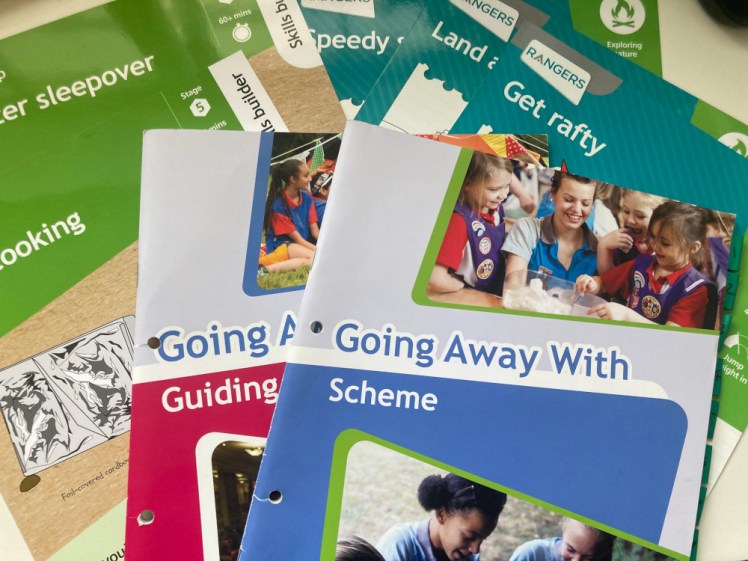 A pile of Ranger camp resources, including the Going Away With books, some UMA cards and some Have Adventures Skills Builder cards.