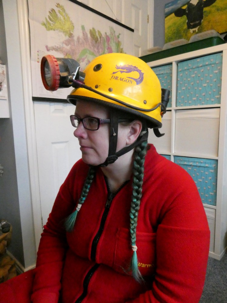 Me, in my red undersuit wearing my helmet. It's a very heavy yellow fibreglass one with a purple Dragon logo on the side. My lamp is also attached to it, the lamp piece sticking out about four inches from the front and a short wire connecting it to the battery tied to the back.