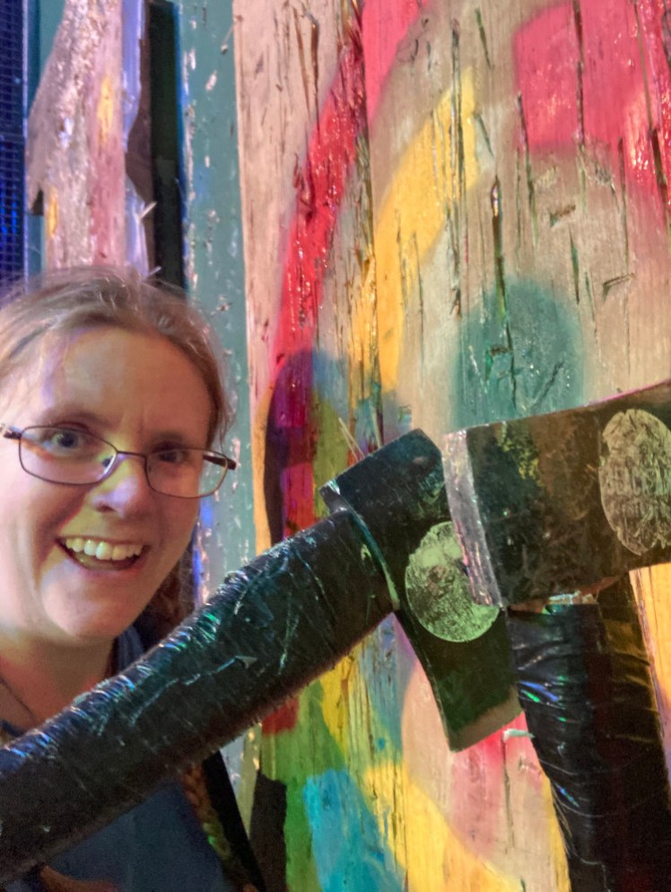 A selfie with two axes in the neon spraypainted target.