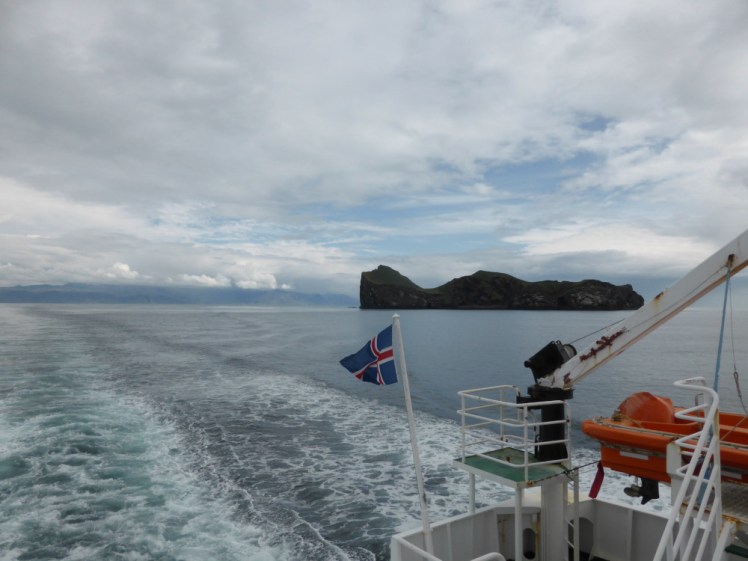 Sailing across to Heimaey. You can see the back of the ferry and a rocky island that looks like a molar sticking out of the sea.