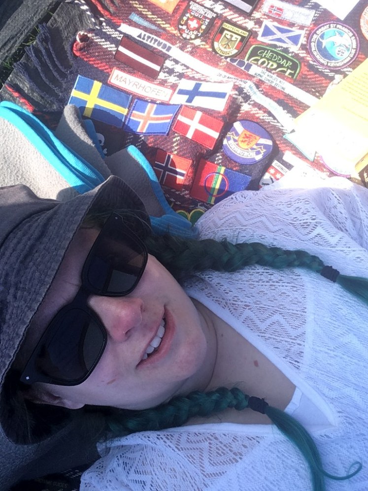 Lying on my camp blankets in the porch of my tent. I'm using the grey blanket as a pillow and then tartan blanket as a mat, wearing a white lacy dress. In the shade, it's hard to tell that my plaits are actually green.