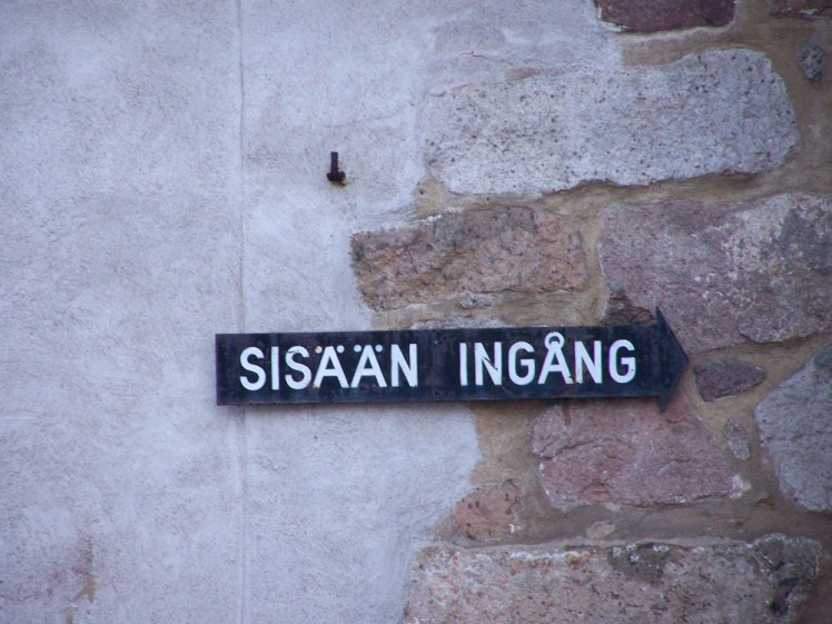 A black sign with white writing saying "Entrance" in Finnish and Swedish. Finnish "Sisään" means nothing to me but I can understand the Swedish "ingång"